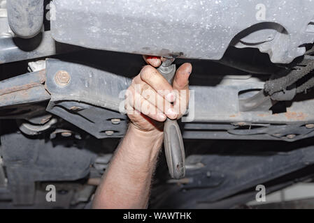 Mechaniker bei der Arbeit. Eine Schraube mit dem Akkuschrauber befestigen Stockfoto