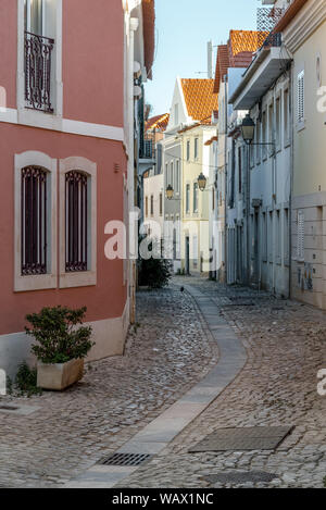 Verwinkelten engen, kopfsteingepflasterten Gasse entfernt zwischen traditionellen Steinhäusern in Cascais Portugal führenden Stockfoto