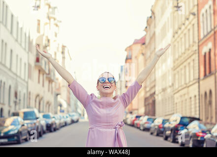 Glückliche Frau Gefühl sich mit den Armen in der Stadt öffnen Zurück Licht genießen Ferienhäuser Stockfoto