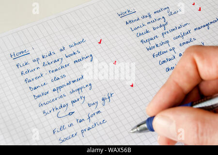 Liste „To Do“. Konzept der Work-Life-Balance. Nahaufnahme der Hand eines Mannes mit Stift, der eine handschriftliche Liste von Aufgaben zu Hause und am Arbeitsplatz verfolgt. Stockfoto