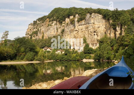 Kanus Kajaks auf dem Flussbett mit La Roque-Gageac im Hintergrund Stockfoto