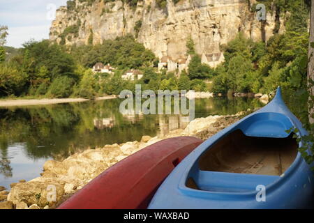 Kanus Kajaks auf dem Flussbett mit La Roque-Gageac im Hintergrund Stockfoto