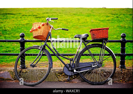 1940 Kriegszeit Wochenende, Lytham, Lancashire, UK. Zwiebel Verkäufer Fahrrad mit Weidenkörbe gegen Geländer gelehnt Stockfoto