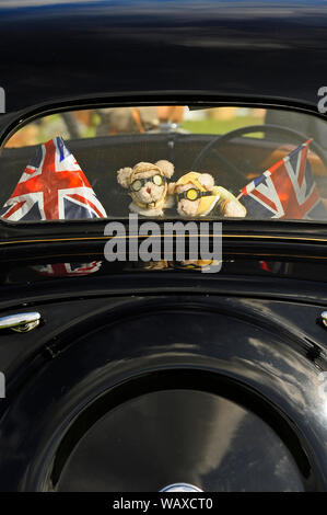 1940 Kriegszeit Wochenende, Lytham, Lancashire, UK. Teddybären in Fliegen, Schutzbrillen und Helme durch das hintere Fenster der alten Austin Auto suchen Stockfoto