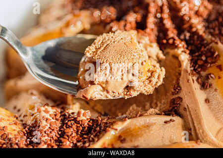 Schokolade Eis auf einem Löffel schließen. Chocolate Chips, apricot Füllung. Stockfoto
