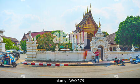 CHIANG MAI, THAILAND - 2. Mai 2019: Die geschnitzten Tor vor reich verzierten Wat Chang Taem Tempel, mit Schnitzereien, Spalten eingerichtet, zwei müde Dach Stockfoto