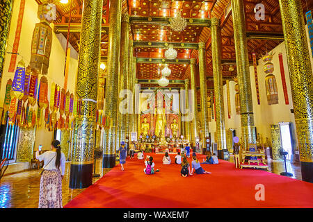 CHIANG MAI, THAILAND - 2. Mai 2019: Phra Viharn Luang Gebetsraum mit hohen Holz spalten, mit feinen Mustern bedeckt, vintage Kronleuchter aus Glas und Stockfoto