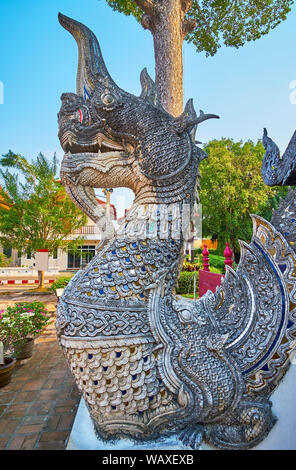 Nahaufnahme der geschnitzten Naga Schlange Hüter der Bhuridatto Viharn, mit Relief Waagen und bunten Spiegel Stücken dekoriert, Wat Chedi Luang, Chiang Mai, T Stockfoto