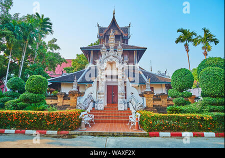 Die Fassade der Ho Trai (heilige Texte storage) und das Museum der Wat Chedi Luang mit pyathat Dach, verzierte Tor- und MOM-mythischen Wächter, umgeben von zu Stockfoto