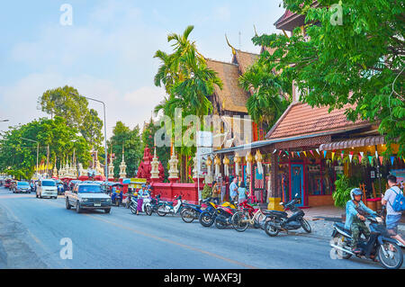 CHIANG MAI, THAILAND - 2. Mai 2019: Die Straße vor Wat Phantao Tempel mit der Zeile der geparkten tuk tuks, Mopeds und Autos fahren, am 2. Mai in Chiang Stockfoto