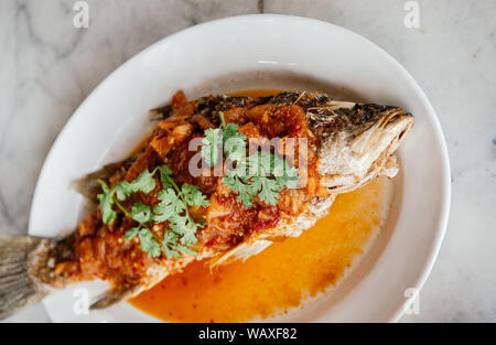 Frittierter Fisch mit süß-saure Chilisauce (Pla Rad Prik) top mit Koriander Koriander - traditionelle thailändische Home Kochen Stockfoto