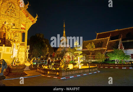 Die kleine Formschnitt Garten ist vor Der Viharn und Chedi des Wat Mahawan Tempel, Chiang Mai, Thailand Stockfoto