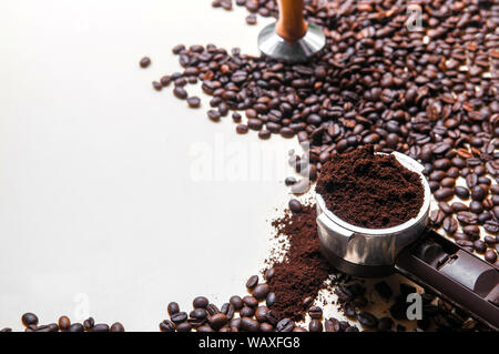 Gerösteten Arabica Bohnen, gemahlenen Kaffee in portafilter mit einigen, verschüttet und verschwommen auf weißem Hintergrund whit Copy space Stampfer Stockfoto