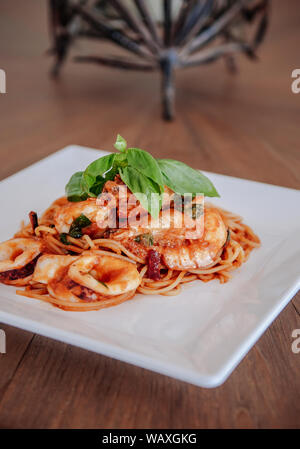 Würzige Italienisch Meeresfrüchte Spaghetti alle Sugo Arrabbiata mit frischem Basilikum auf die Oberseite in weiße Platte, Region Latium Nudelgerichte. Stockfoto