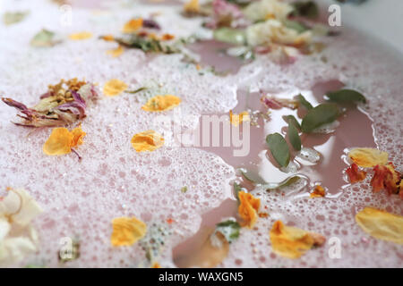 Badewanne mit Schaum und Blütenblätter Stockfoto