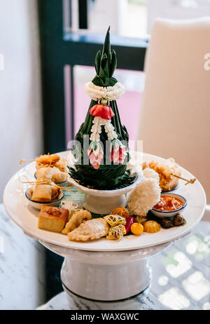 Thai verschiedene traditionelle Dessert Snack, puff Curry, Reis Cracker, Pudding, Frühlingsrollen, usw. auf weißer Keramik Sockel fach Nahaufnahme Stockfoto