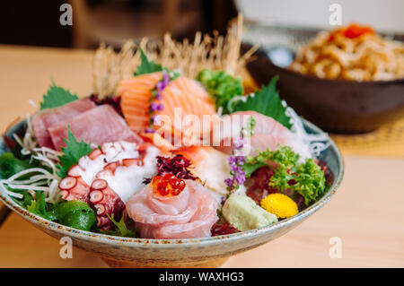 Verschiedene frische japanische Otoro Thunfisch-sashimi, Otoro, Tako, Lachs, Hamachi und Wasabi in Handwerk Keramik Schüssel, bis Schuß schließen Stockfoto