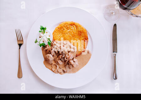 Zürich stil Kalbfleisch Eintopf mit cremiger mushroom gravy Soße und gebratene Rösti Kartoffel, lokalen Schweizer Küche in weiße Platte Stockfoto