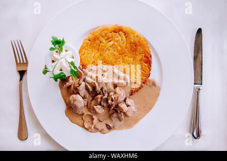 Zürich stil Kalbfleisch Eintopf mit cremiger mushroom gravy Soße und gebratene Rösti Kartoffel, lokalen Schweizer Küche in weiße Platte Stockfoto