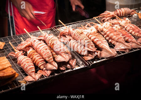 Grossen Grill squids Spieß an der Straße essen in lokalen Night Market in Bangkok, Thailand Abschaltdruck Stockfoto