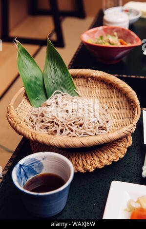 Tempura kalt Zaru Soba mit Soße und Wasabi in Bambus Teller und Schale am Schwarzen Tisch Set Stockfoto