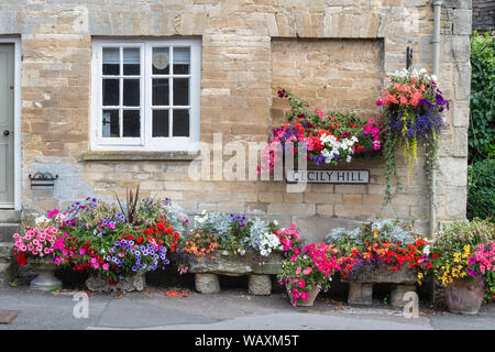 Blumen hängende Körbe und Blume Pflanzmaschinen außerhalb der Tontine Gebäude entlang Cecily Hill, Cirencester, Cotswolds, Gloucestershire, England Stockfoto