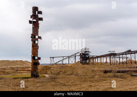 Wüste industrielle Landschaft mit stationären Rusty gravitativen Separator von Sand und Kies, seltsame rostiges Rohr wie ein Totem Pole auf der foregr Stockfoto