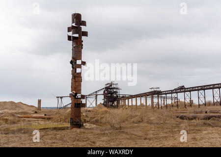 Wüste industrielle Landschaft mit stationären Rusty gravitativen Separator von Sand und Kies, seltsame rostiges Rohr wie ein Totem Pole auf der foregr Stockfoto