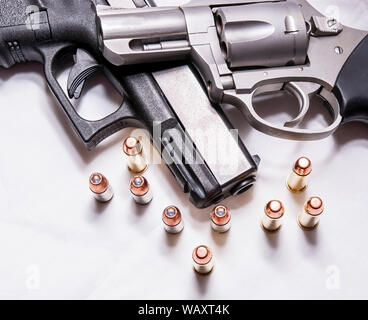 Eine Brüskierung gerochen, Edelstahl 357 Magnum Revolver auf einem schwarzen 9 mm Pistole mit mehreren Kugeln für jedes Kaliber vor Ihnen auf weißem Hintergrund Stockfoto