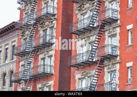 Roten Backsteinfassade und Feuer Treppen. Harlem, NYC. Stockfoto