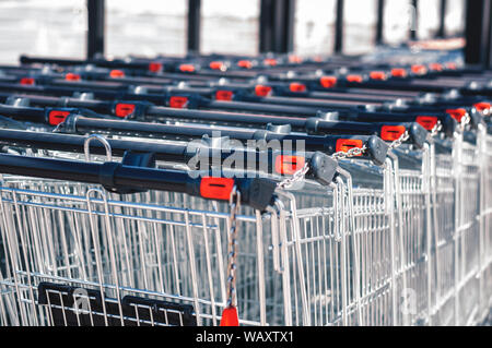 Shopping Carts im Store in einer Reihe auf dem Parkplatz zusammengebaut. Close-up Stockfoto