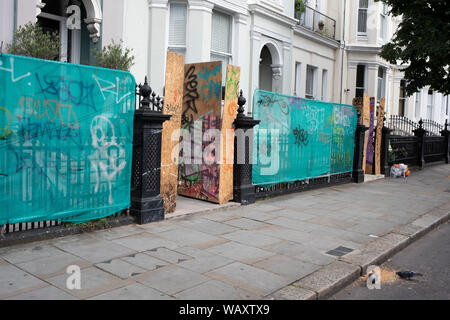 Häuser und Geschäfte eingezäunt sind und stieg bis in die Vorbereitung auf die anstehenden Notting Hill Karneval am 13.08.2008 in London, England 22 2019, Vereinigtes Königreich. Einen erwarteten 1 Millionen Feiernden werden erwartet, Karneval, am Wochenende zu besuchen, so viele Besitzer haben beschlossen, ihre Eigenschaften als Vorsichtsmaßnahme zu schützen. Stockfoto