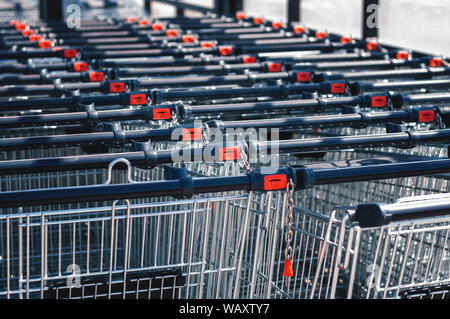 Shopping Carts im Store in einer Reihe auf dem Parkplatz zusammengebaut. Close-up Stockfoto