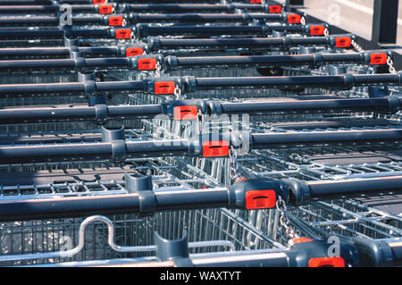 Shopping Carts im Store in einer Reihe auf dem Parkplatz zusammengebaut. Close-up Stockfoto