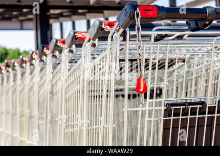 Shopping Carts im Store in einer Reihe auf dem Parkplatz zusammengebaut. Close-up Stockfoto