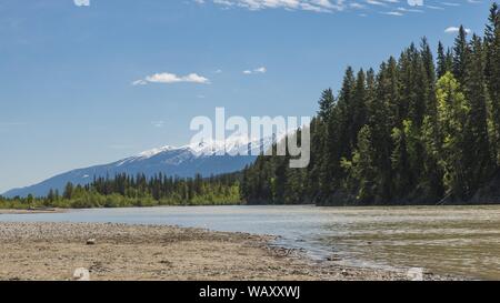 Schöne breite Aufnahme von Bäumen und Bergen in der Nähe des Körpers Von Wasser unter einem blauen Himmel Stockfoto