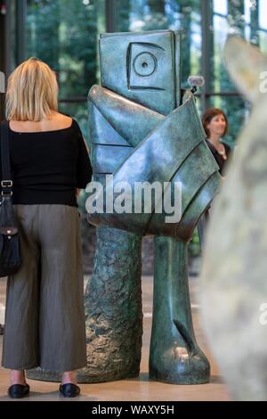 Wuppertal, Deutschland. 22 Aug, 2019. Ein Journalist steht im Skulpturenpark Waldfrieden vor dem Bronze Skulptur' Personnage' (1982) von Joan Miro. Vom 24. August bis 24. November 2019, Skulpturenpark Waldfrieden zeigt Skulpturen von Ende Joan Miros's Arbeit. Credit: Marius Becker/dpa/Alamy leben Nachrichten Stockfoto