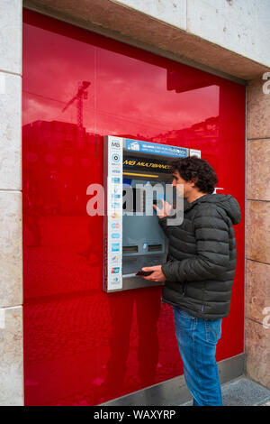 Mann an Geldautomaten Stockfoto