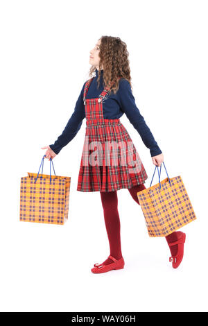 Kind mit einem gelben Verpackung karierten Textur auf weißem Hintergrund. Urlaub, Shopping. Kid Happy Shopping in der Mall. Glückliches Mädchen mit Stockfoto