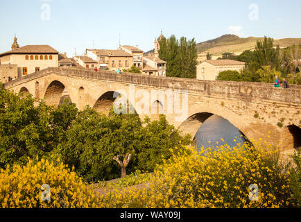 Pilger auf der mittelalterlichen Steinbrücke Puente Romanico über den Fluss Arga in Puente la Reina Navarra Nordspanien Teil des Camino de Santiago Stockfoto