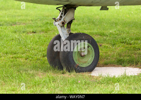 Alte Gehäuse eines alten Flugzeugs in der Nähe auf einem Hintergrund von grünem Gras. Stockfoto