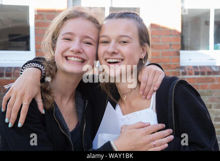 Kingston Gymnasiasten feiern und einander beglückwünschen, als sie ihre GCSE Ergebnisse erhalten Stockfoto