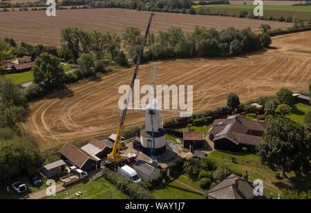 Ein Kran hebt neue Segel an, wenn sie an der Saxtead Green Post Mill in der Nähe von Framlingham, Suffolk, einer Maismühle aus dem 18. Jahrhundert, im Rahmen eines £250,000-Naturschutzprojekts montiert werden. Stockfoto