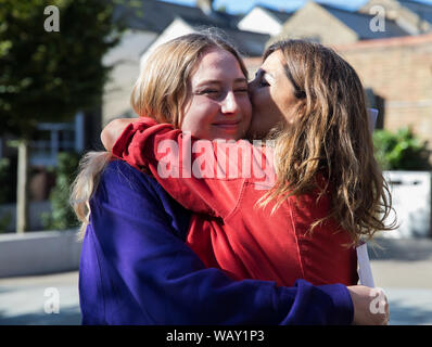 Kingston Gymnasiasten feiern und einander beglückwünschen, als sie ihre GCSE Ergebnisse erhalten Stockfoto