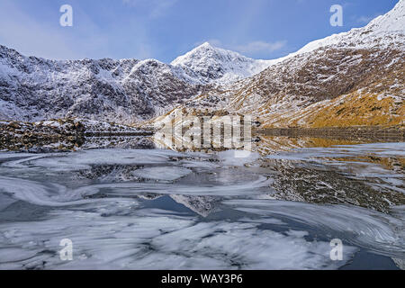 Mount Snowdon nieder in Llyn Llydaw angezeigt Eisformationen auf der Wasseroberfläche Snowdonia National Park North Wales UK März 2018 Stockfoto