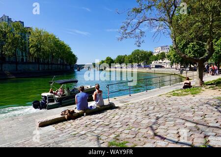 Paar entspannen mit Wein in der Paris Plage Gebiet entlang der Seine während der warmen Tage im August, Paris, Frankreich. Stockfoto