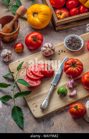 Tomaten auf Schneidebrett mit Messer Stockfoto