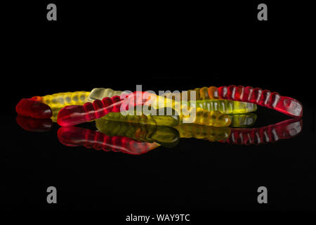 Gruppe von fünf ganze Bunte Jelly Wurm candy auf schwarzem Glas isoliert Stockfoto