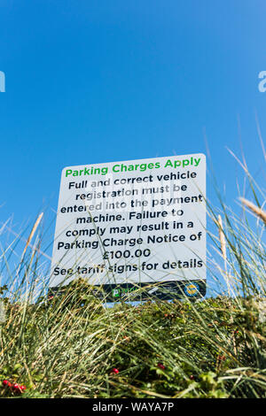 Ein Schild mit Informationen über Parkplatz Gebühren auf den Fistral Parkplatz in Newquay in Cornwall. Stockfoto