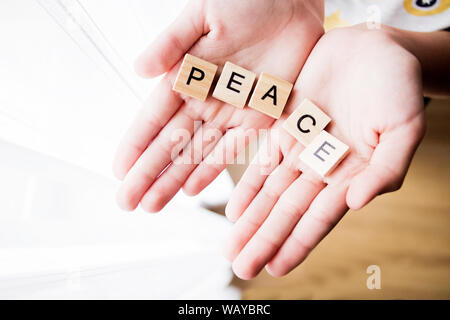 Das Wort Frieden in kubischen Briefe in Händen geschrieben ist, selektive konzentrieren. Stockfoto